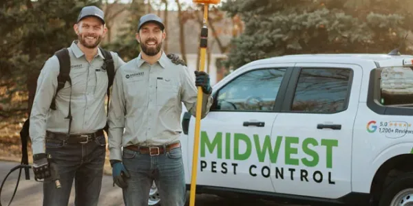 Owners standing next to Midwest Pest Control truck